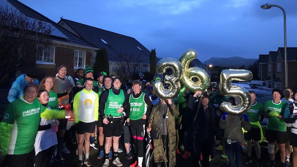 Well-wishers with balloons spelling out "365" gather ahead of Gary McKee's final marathon