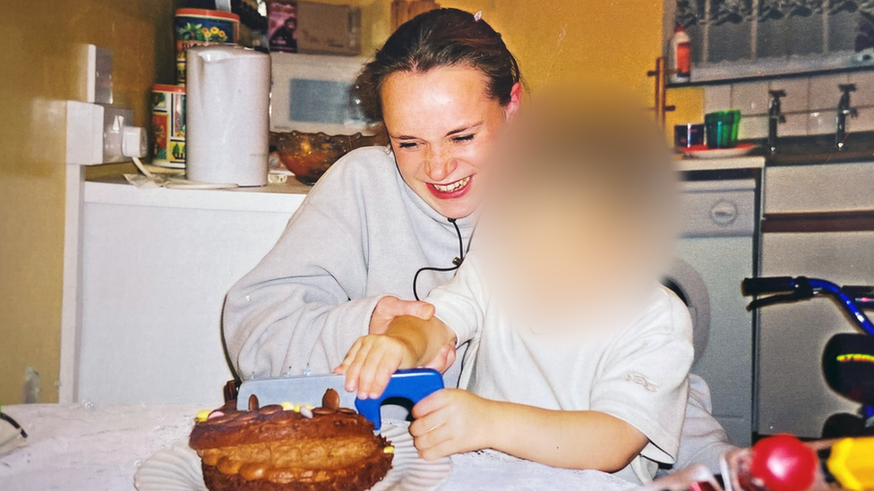 Claire Holland and one of her children cutting a birthday cake