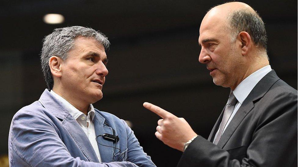 Greece's Finance Minister Euclid Tsakalotos (L) speaks with European Commissioner for Economic and Financial Affairs, Taxation and Customs Pierre Moscovici