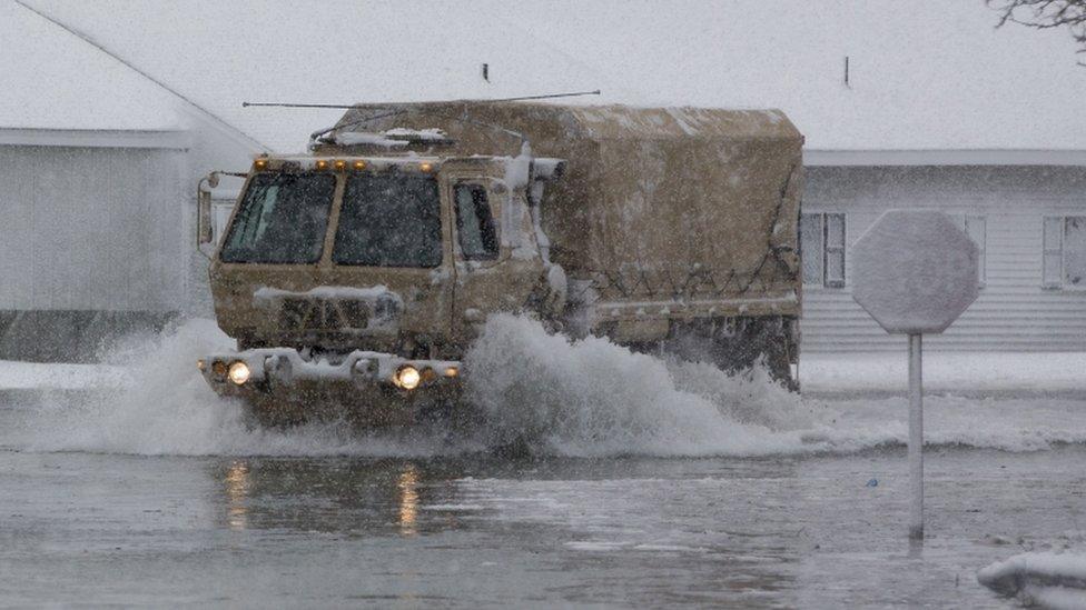 A National Guard vehicle patrols streets in flooded Massachusetts