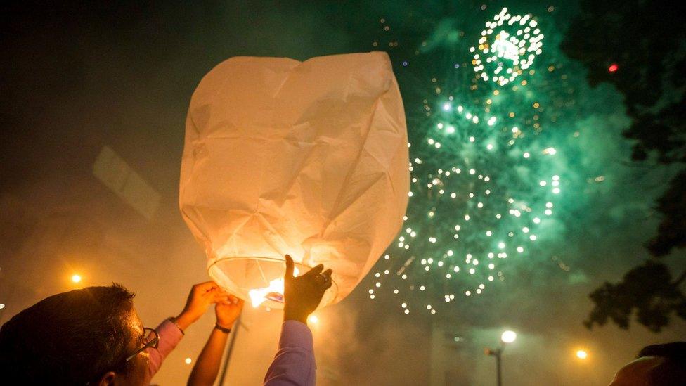 People release sky lanterns during New Year celebrations at France Square in Caracas, Venezuela, on 1 January, 2016