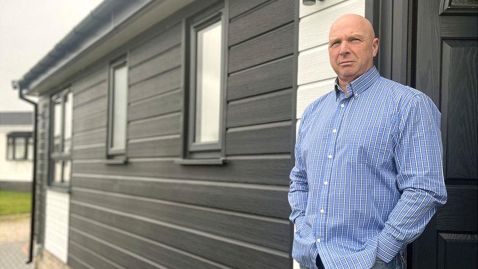 Mike Chesworth standing in the doorway of his caravan