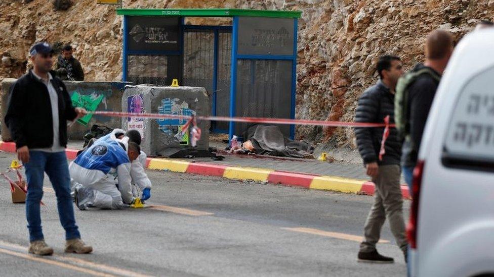 Israeli forces and forensic inspect the site of a shooting attack outside the West Bank settlement of Givat Asaf, north-east of Ramallah, on 13 December 2018.