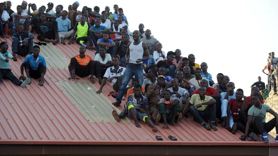 Supporters sit on the roof of a house in Kaduna to watch the African Cup of Nations qualification match between Egypt and Nigeria, on 25 March 2016