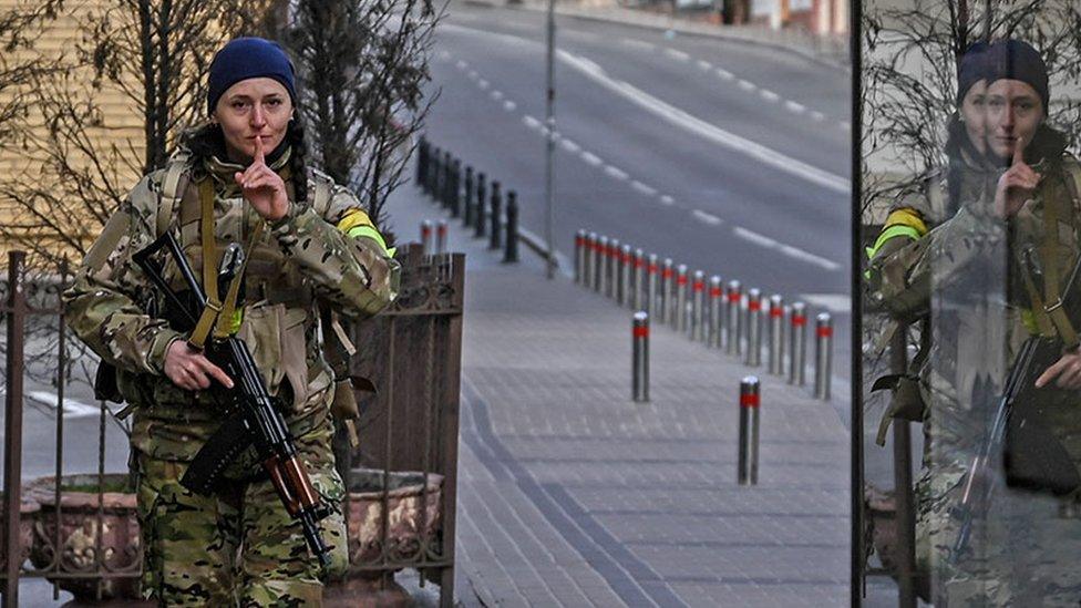 A member of Ukrainian forces patrols the streets at Maidan square in Kyiv on 27 February 2022