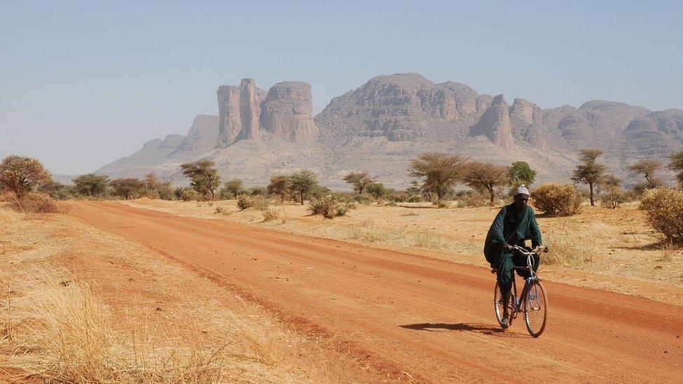 Malian man on bicycle in Sahara desert, Mali, October 2005