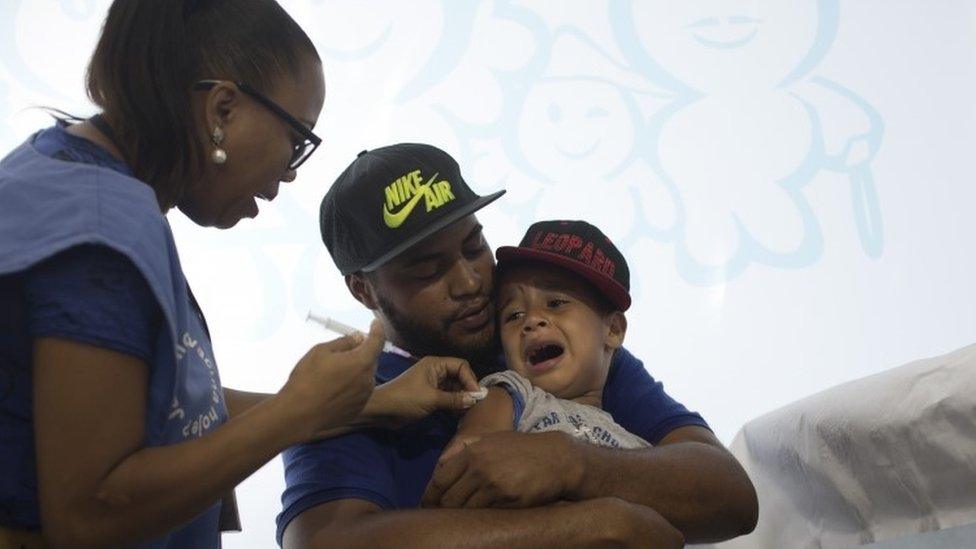 A nurse prepares to vaccinate a boy against the H1N1 swine flu virus at a health clinic in Rio de Janeiro, Brazil (25 April 2016)