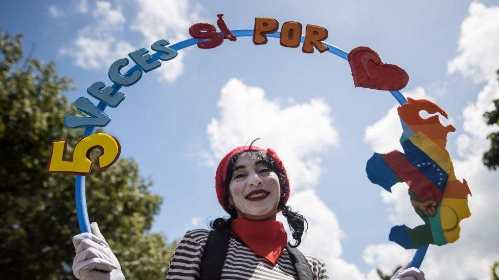 A person holds a sign that reads '5 votes yes for (El Essequibo)' as they participate in a demonstration in support of the consultative referendum on El Essequibo in Caracas, Venezuela, 15 November 2023.