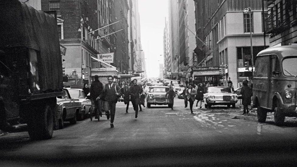 Crowds chasing The Beatles down a New York street