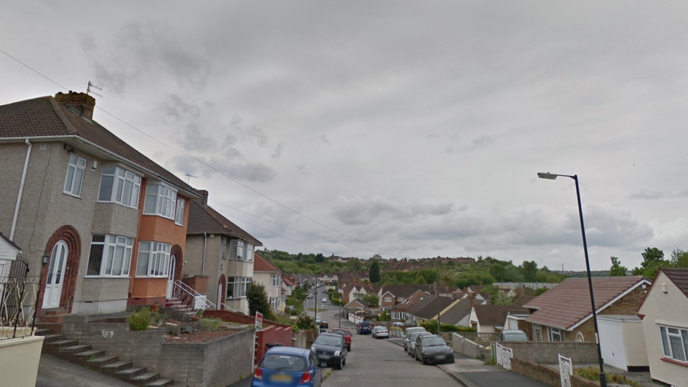 View from the top of a street with parked cars