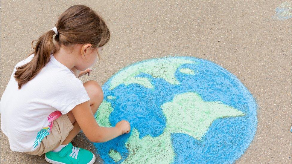 Girl drawing the globe.