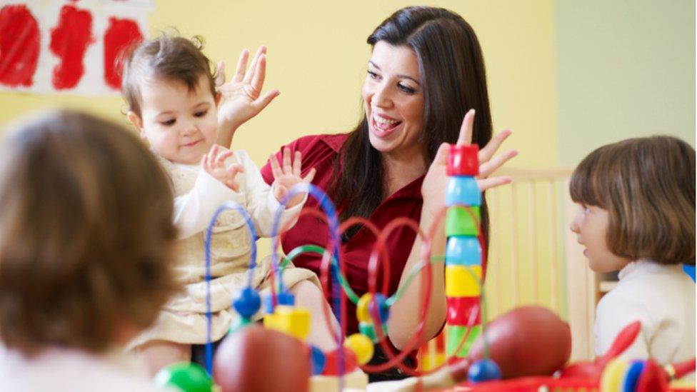 Nursery worker with baby