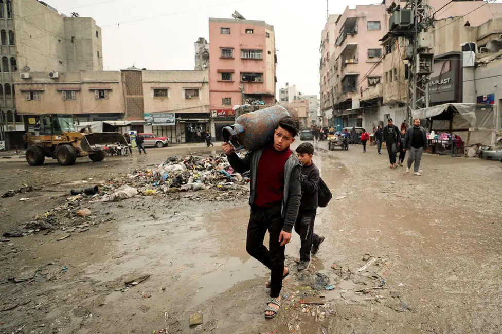 Boy carries a gas cylinder in Gaza