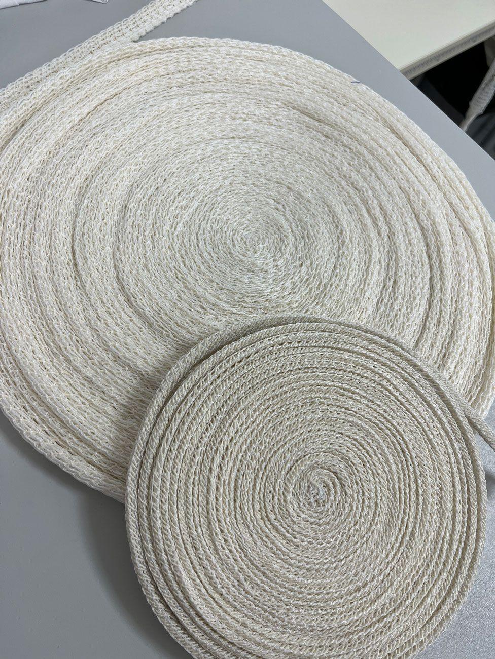 Two rolls of meat netting, one smaller one on top of another. They are off-white in colour and rolled up tightly in two coils