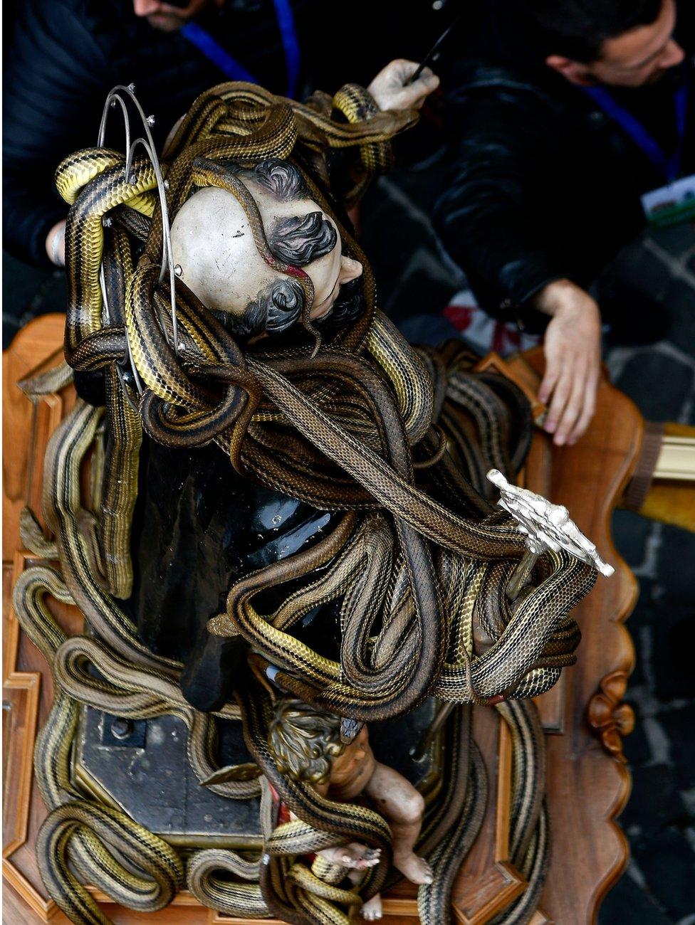 A statue of Saint Domenico covered with live snakes is carried by faithfuls during an annual procession in the streets of Cocullo