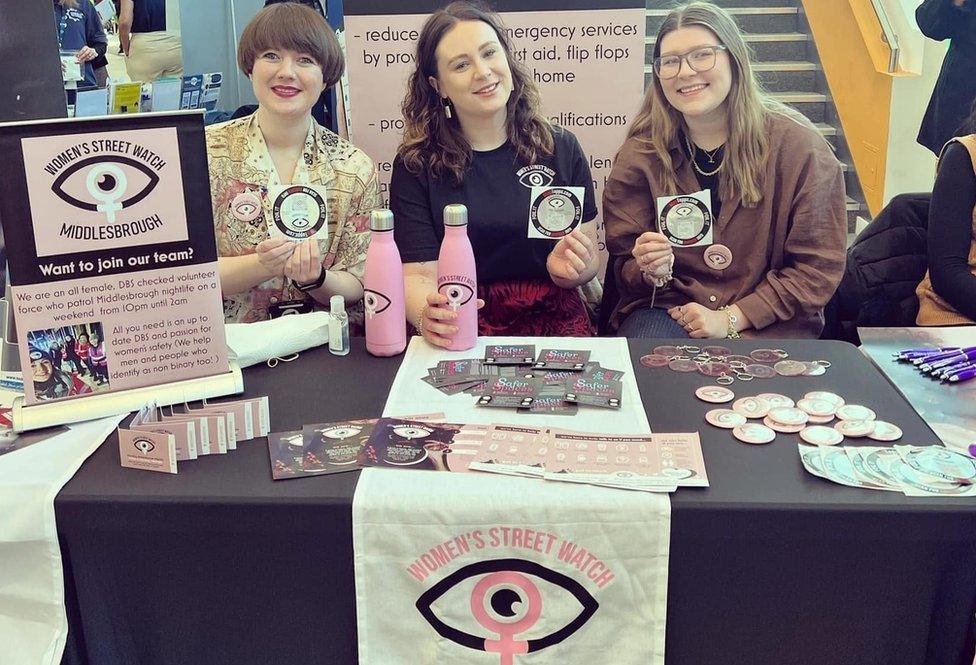 Beth with Jess and another volunteer at an event with foil wrappers and water bottles