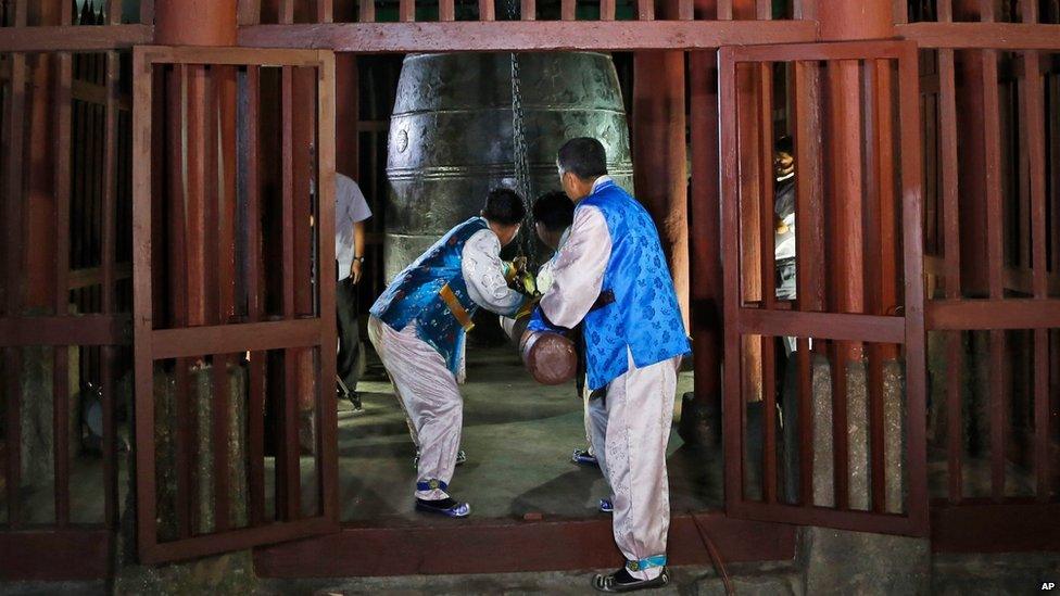 Men in traditional outfits ring a bell to mark the new time zone in a ceremony in Pyongyang on 15 August 2015