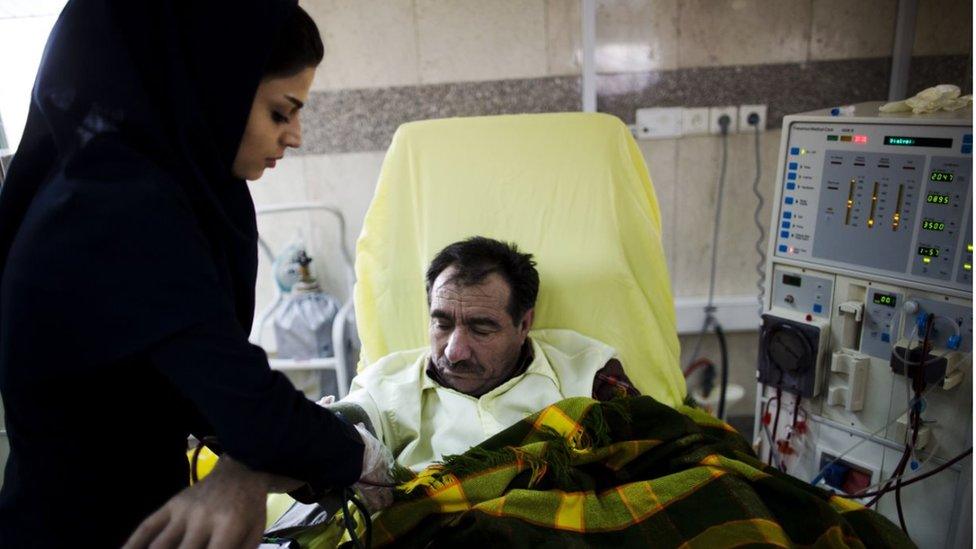 An Iranian nurse measures the blood pressure of a patient at the dialysis ward at the Helal Iran Clinic - file picture