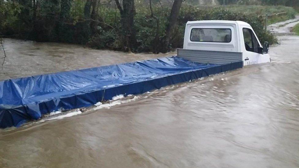 A van driver was rescued from his vehicle at St Clears in Carmarthenshire