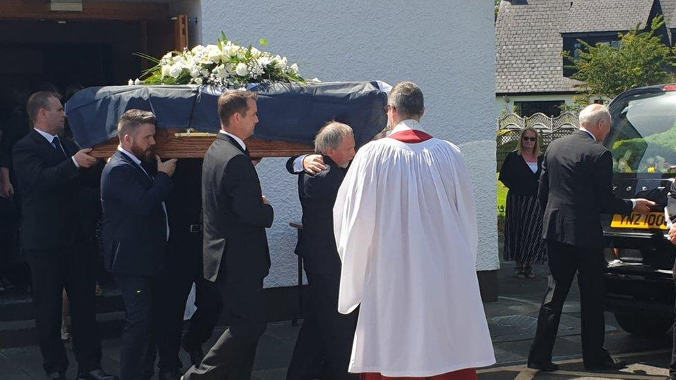 Men carry Ivan Cooper's coffin into St Peter's Church