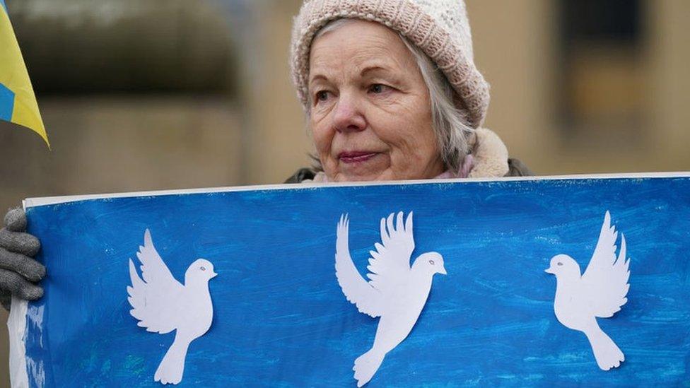 A woman holds a banner as members of northeast Ukrainian community groups gather at Grey's Monument to mark the first anniversary of the Russian invasion of Ukraine, on February 24, 2023 in Newcastle upon Tyne, United Kingdom.