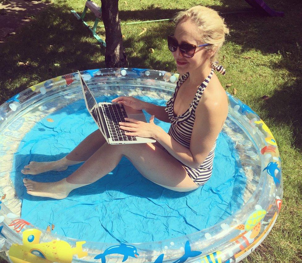 Anna working on her laptop in a paddling pool