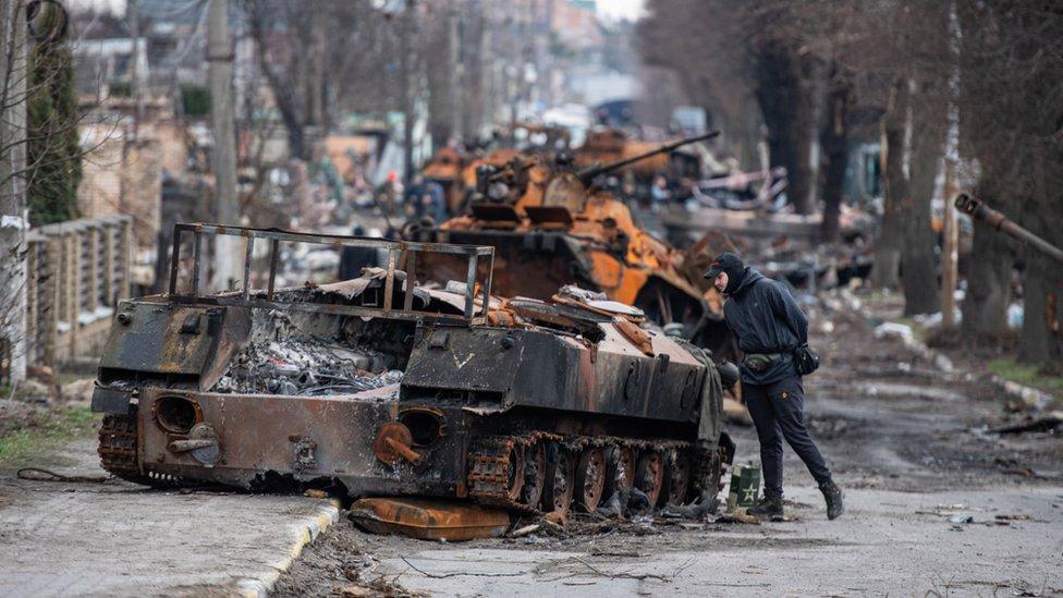 A man looks at a destroyed Russian tank in Irpin, near Kyiv. Photo: April 2022