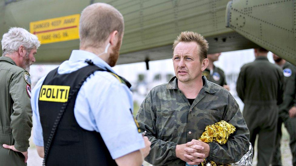 Peter Madsen talks to a police officer in Dragoer Harbor south of Copenhagen on August 11, 2017