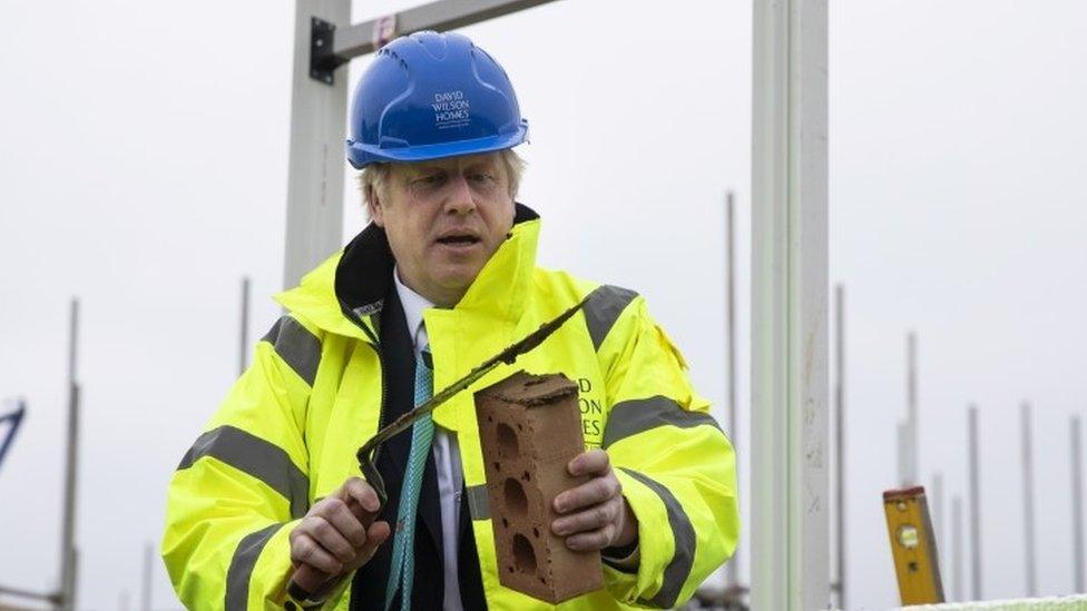 Boris Johnson prepares to lay a brick