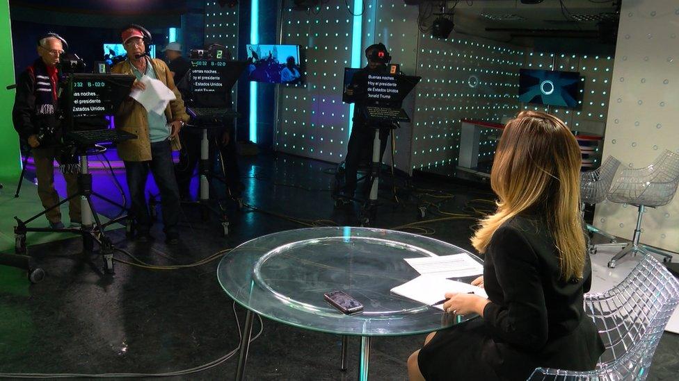 A presenter sits on the set of Canal Caribe's El Mundo ahora