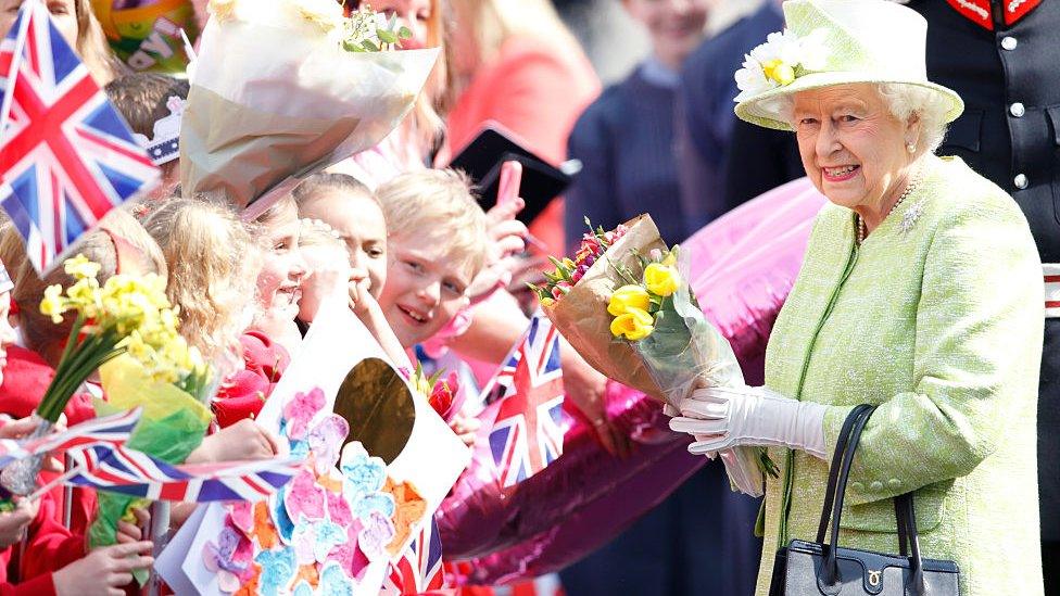 queen elizabeth out in windsor meeting children waving flags