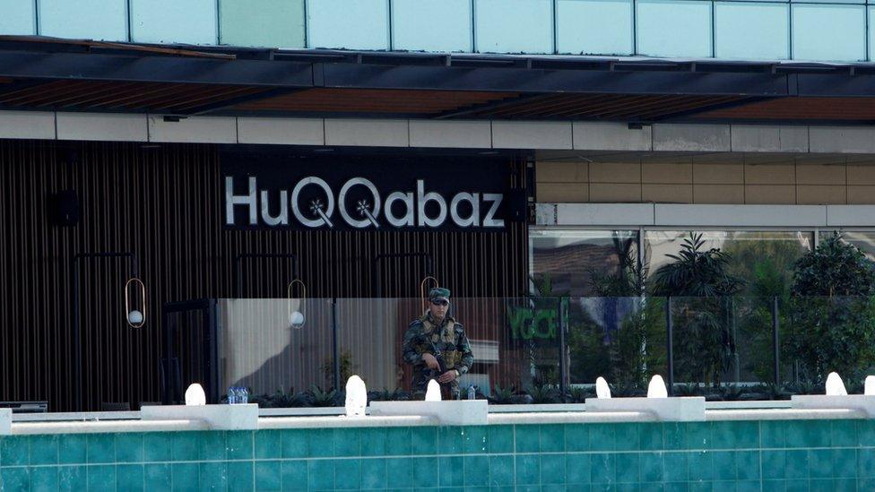 A Kurdish security member stands guard at a restaurant where the attack took place in Irbil