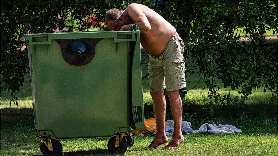 Man looking in bin