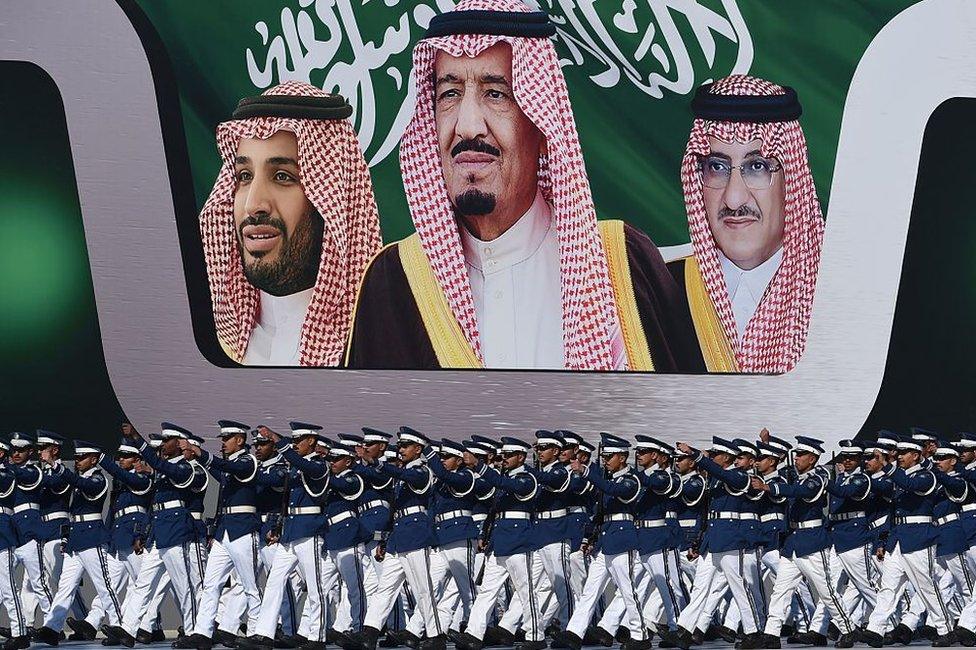 Newly graduated Saudi air force officers march in front of a banner bearing portraits of King Salman (C), then Crown Prince Mohammed bin Nayef (R), and then deputy Crown Prince Mohammed bin Salman at King Salman airbase in Riyadh on 25 January 2017