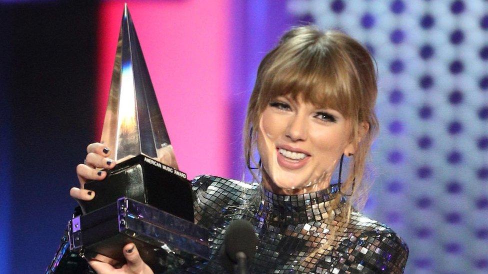 taylor-swift-holding-an-award-at-the-american-music-awards-2018.