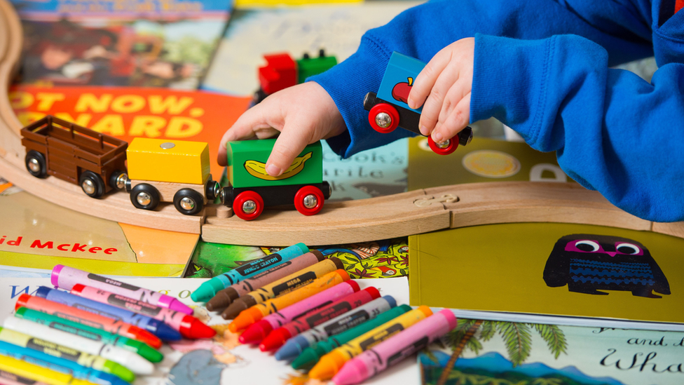 A child play9ing with a toy train set