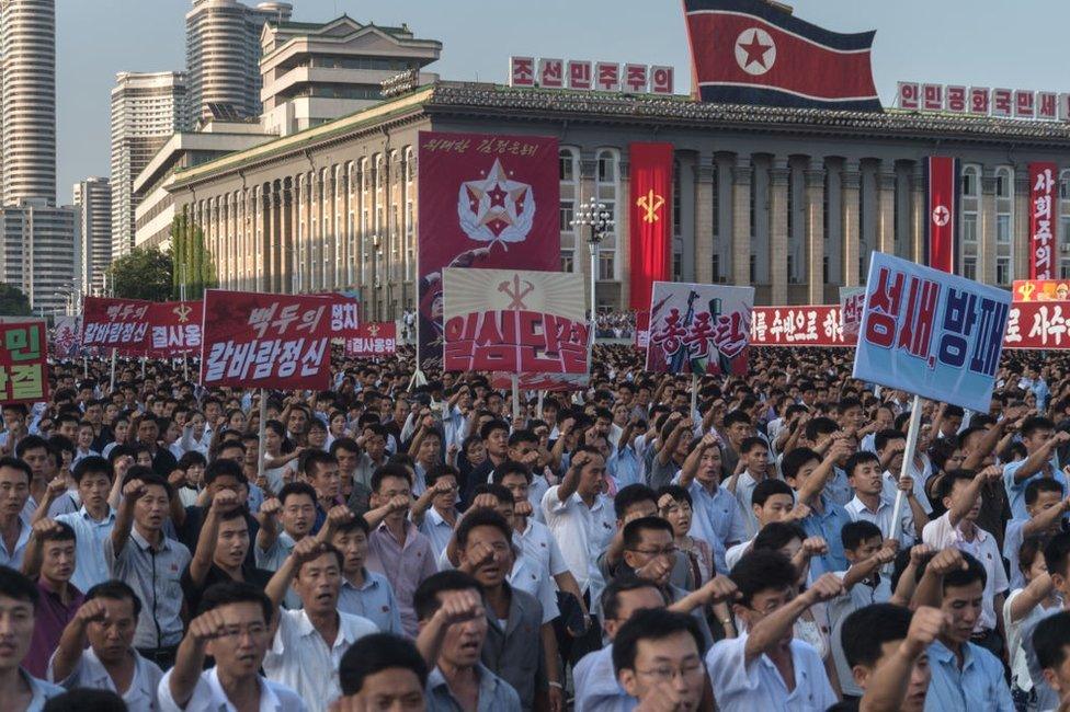 People wave banners and shout slogans as they attend a rally in support of North Korea's stance against the US, on Kim Il-Sung square in Pyongyang