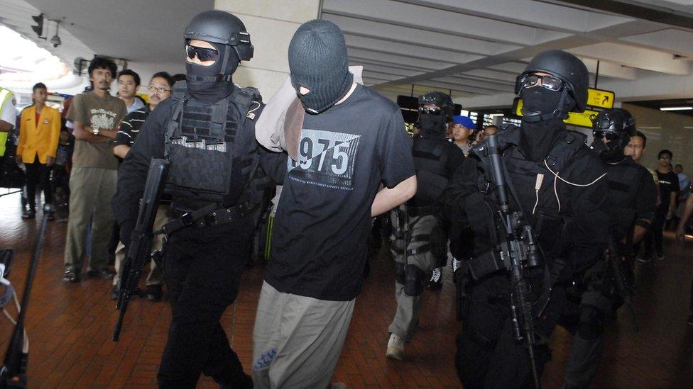 Indonesian anti-terror police from Densus 88 escort four Turks arrested on arrival at Jakarta airport on September 14, 2014