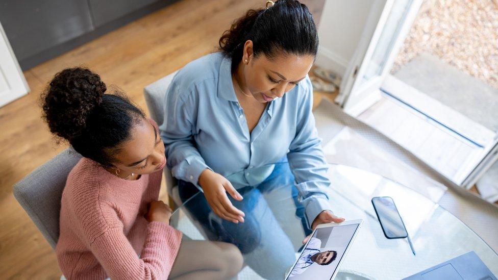 Mother and daughter have a virtual appointment with a doctor from home