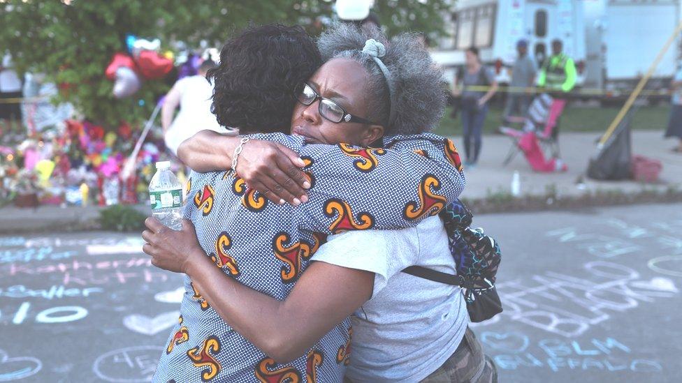 Mourners support each other while visiting a makeshift memorial outside of Tops market on May 15, 2022 in Buffalo, New York.