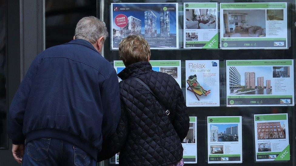 couple look at estate agent window in Manchester