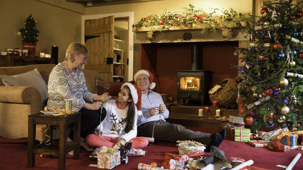 Grandparents opening gifts with child