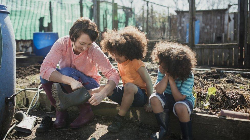 two-children-and-woman-in-allotment.