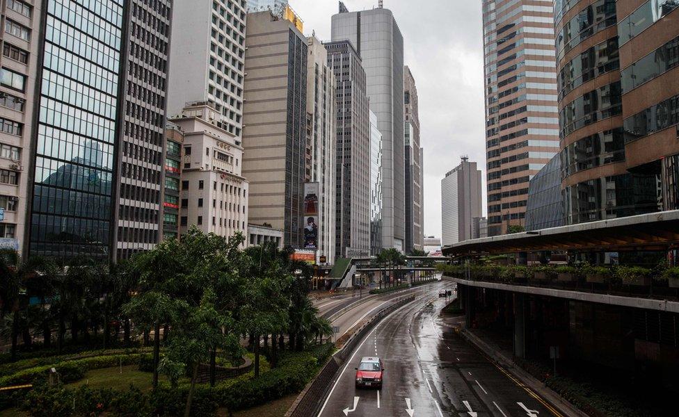 A taxi drives along a deserted main road in a business district in Hong Kong on 21 October 2016.