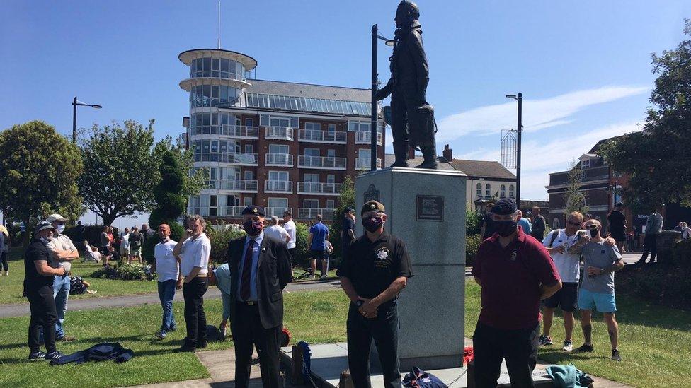 Veterans surround a war memorial