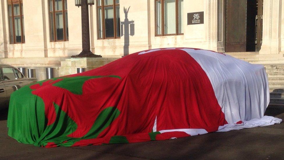 2016: The new Aston Martin draped in a Welsh flag outside the Welsh government offices in Cardiff