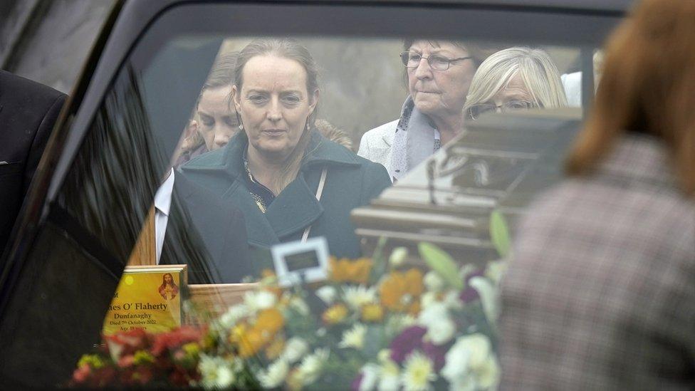 Tracey O'Flaherty, the widow of James O'Flaherty, watches as his coffin arrives for his funeral mass at St Mary's Church, Derrybeg