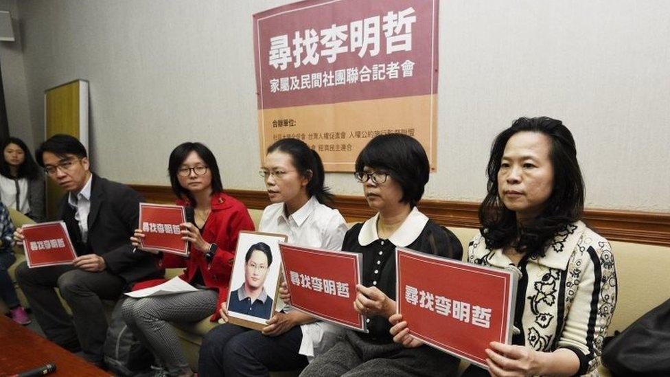 Lee Ching-yu, (third from right) holds up a photo of her missing husband and Taiwanese pro-democracy activist Lee Ming-che during a press conference with other human rights activists in Taipei (24 March 2017)