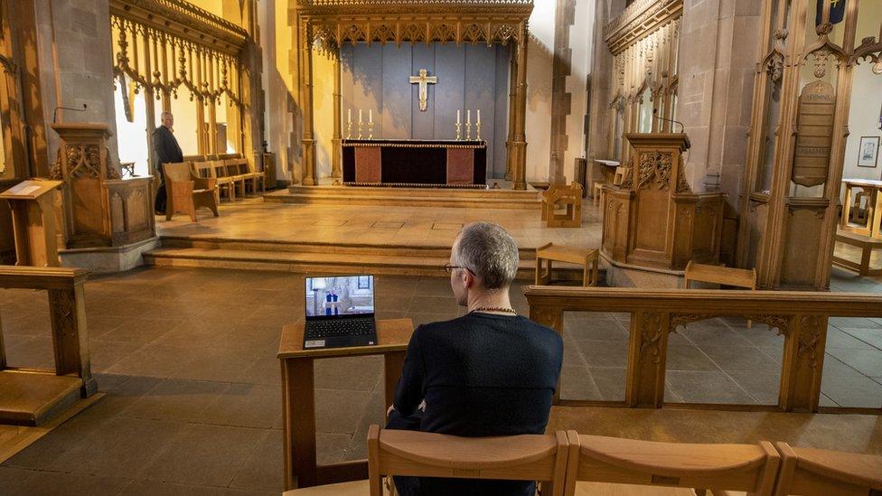 A church parishioner watches a laptop inside Liverpool Parish Church (Our Lady and St Nicholas) in Liverpool