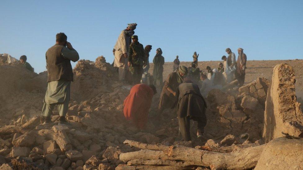 Afghan residents clear debris from a damaged house after earthquake in Sarbuland village in Herat province on 7 October 2023